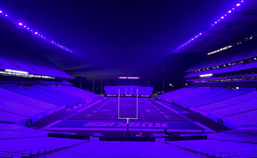 Husky Stadium bathed in purple light