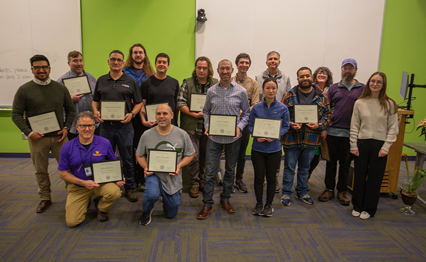 group of people posed together holding diplomas