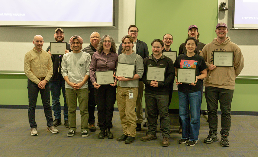group of people posed together holding diplomas