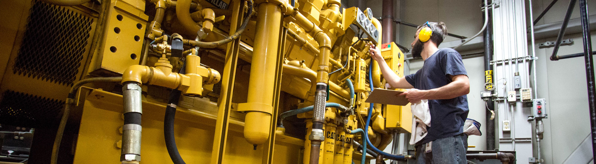 A power plant employee checks on a diesel generator.