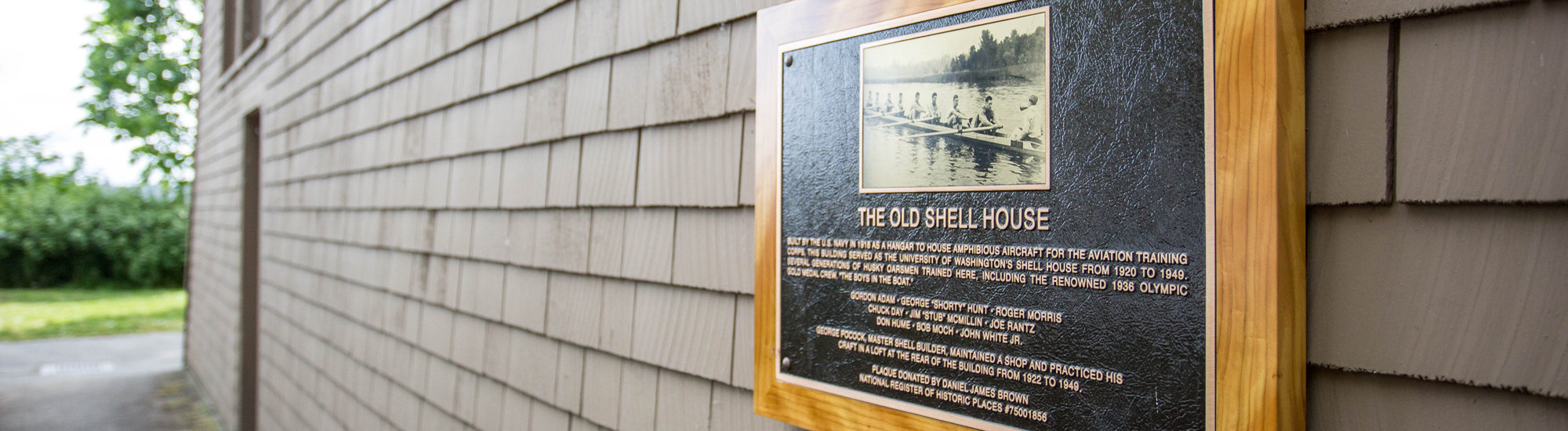 A plaque commemorating UW's crew team on the side of the old canoe house
