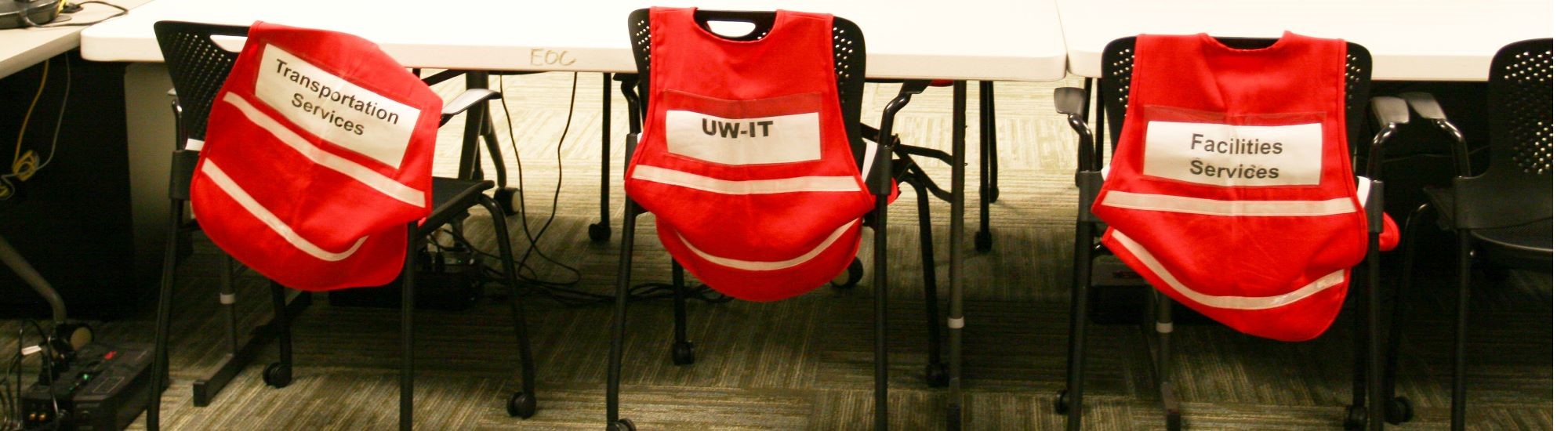 Reflective vests for department representatives draped on chairs