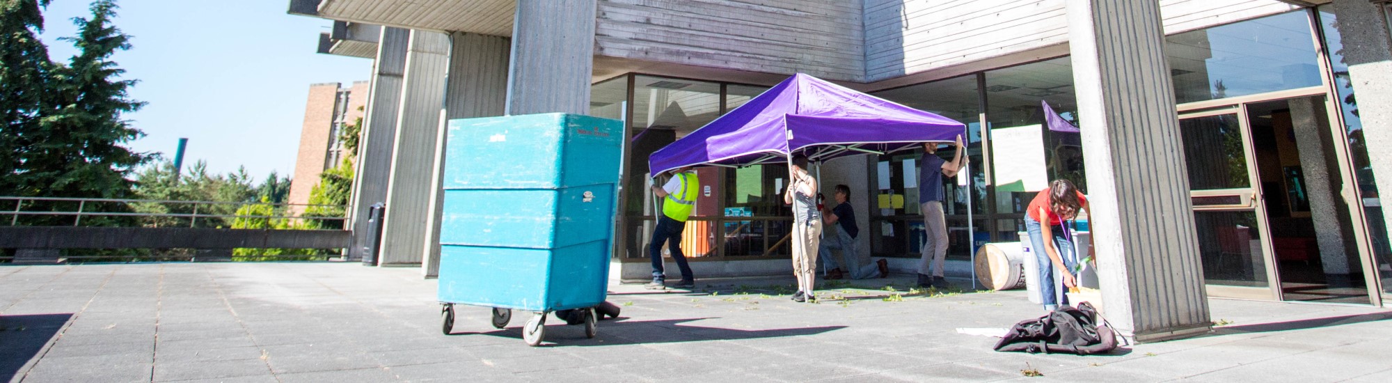 Employees setting up donation station outside a residence halls for students to drop off donations.