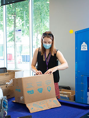 woman taping up a cardboard box