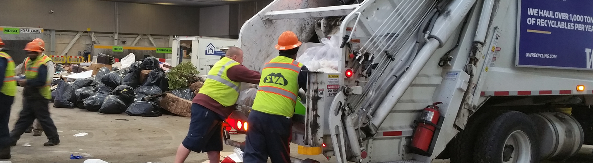 UW Recycling employee and a member of the waste characterization study team work together to empty garbage truck