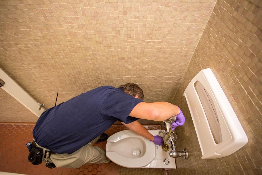 Peter Gorokhovskiy from Facilities Services installs a new toilet in the UW Tower in Seattle, Wash.
