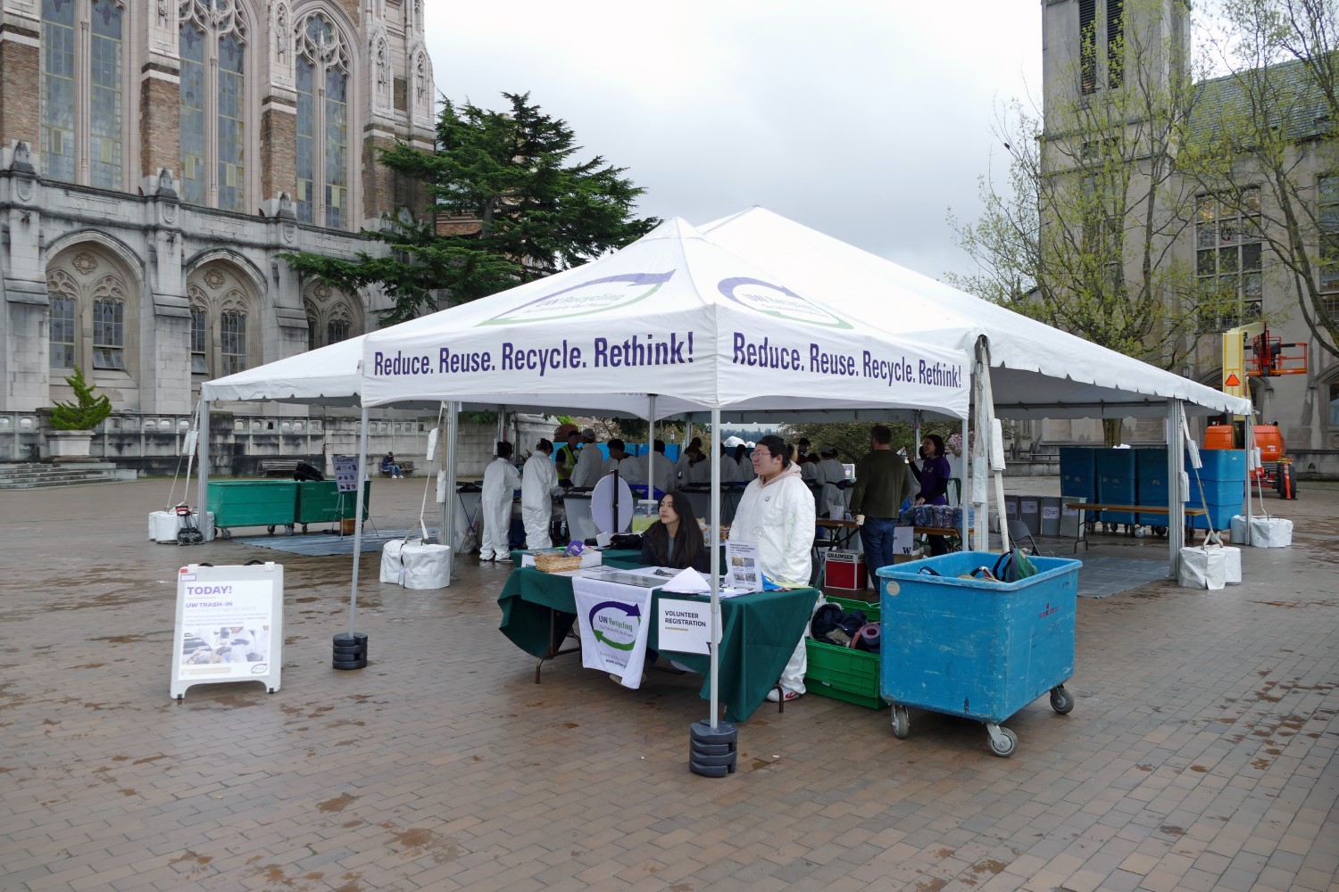 Volunteers sort trash underneath a large tent on UW Red Square. 