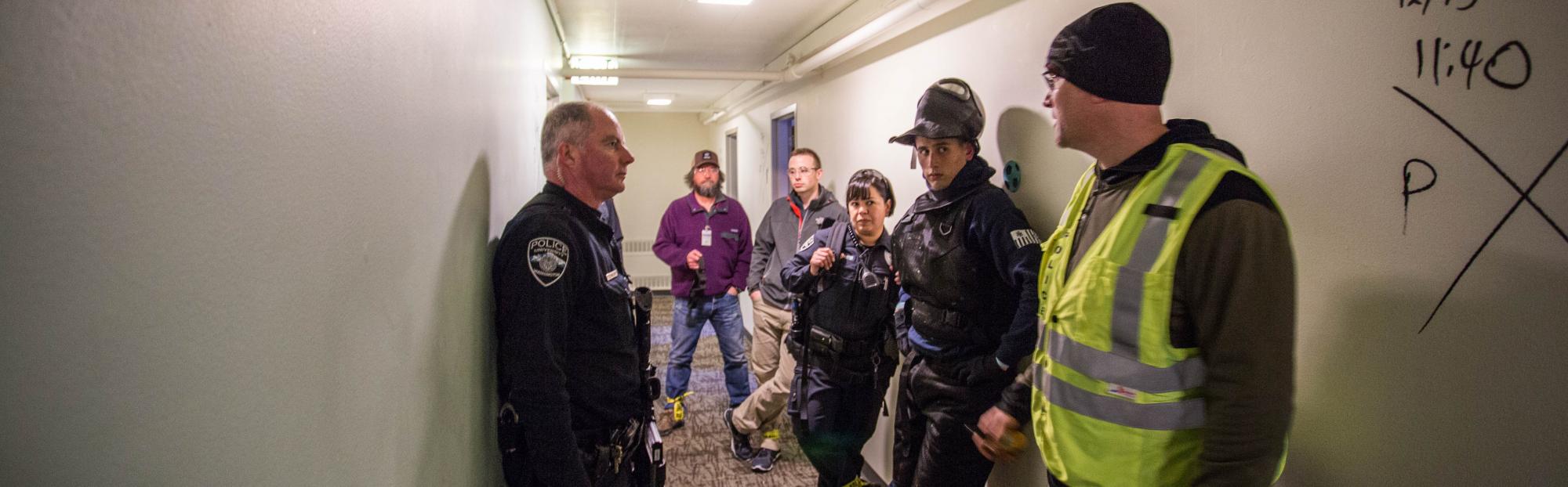 UWPD officers and volunteers debrief after an active shooter training exercise in the empty McCarty Hall.