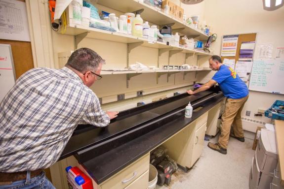 Doug Parshall (left) and Andy Schlais from Facilities Maintenance and Construction work together to install a PaperStone counter top in the Health Sciences Building in Seattle, Wash. on Jan. 13, 2016.