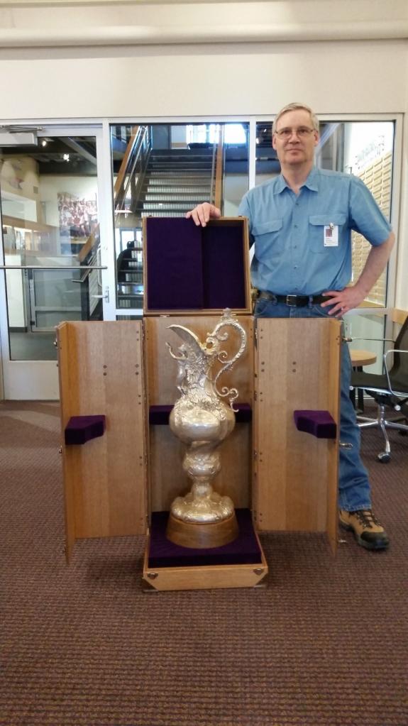 Finish Carpentry Lead Ed McKinley stands with the Varsity Cup case built by his team of finish carpenters in Facilities Construction.