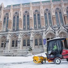snow plow clears snow in front of Suzzallo library