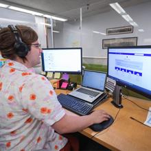person sits at desk with two screens