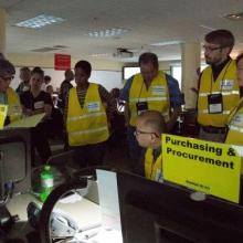 A team of logistics coordinators meet to discuss how to respond to an emergency scenario.