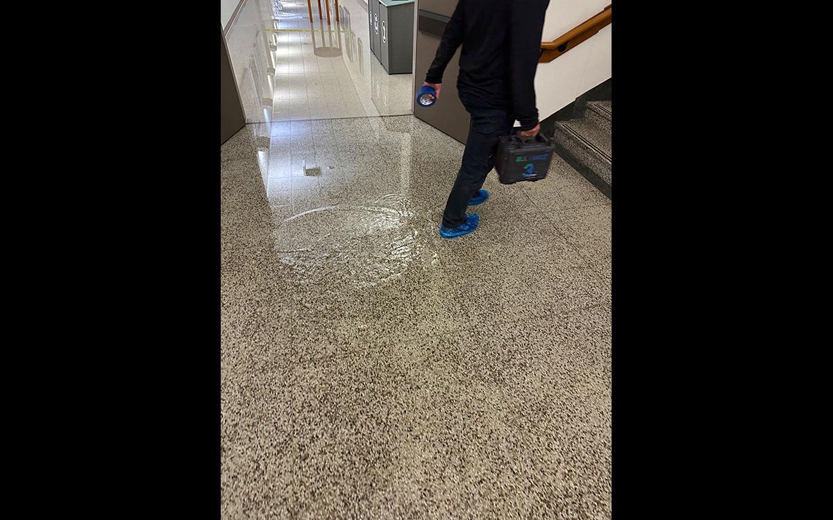 man walking through puddle in stair landing