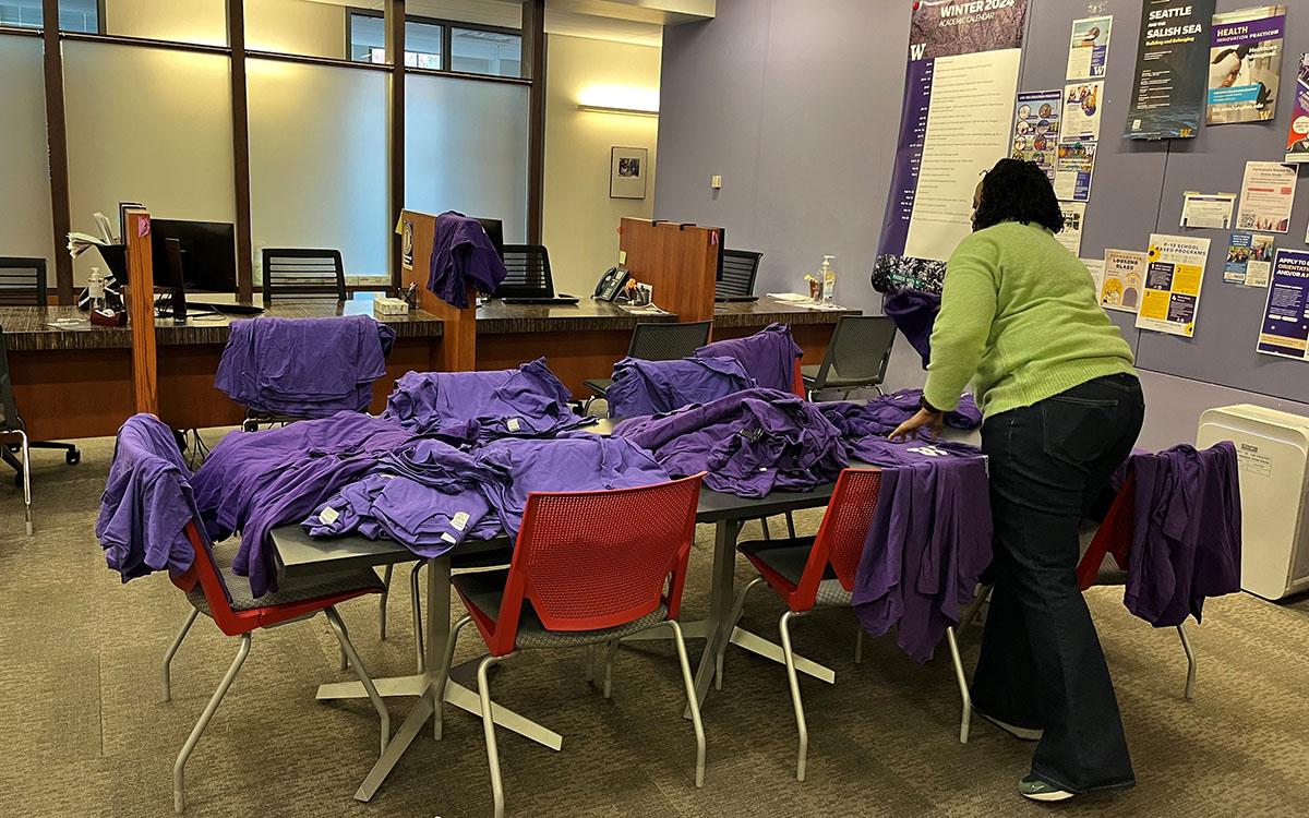 woman laying out t shirts on tables to dry