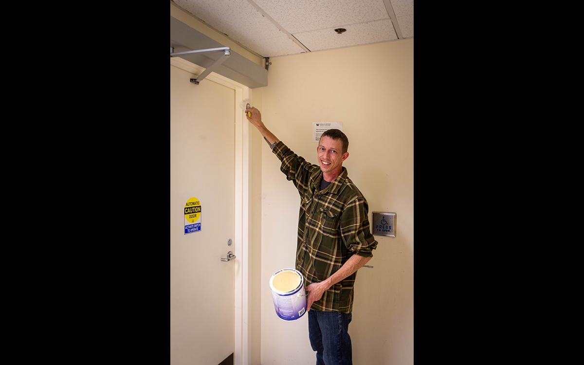 man painting a door