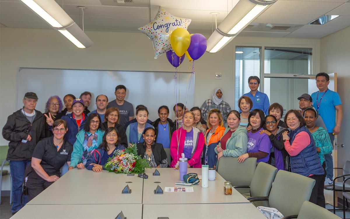 Leula Amaha with surrounded by crowd of co-workers