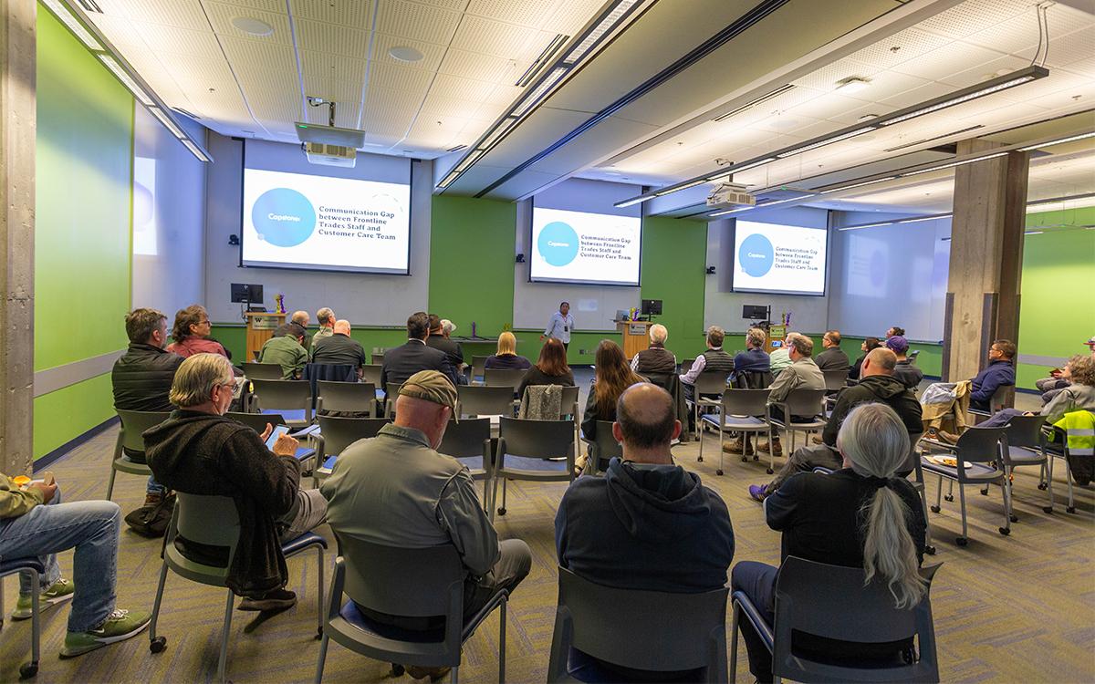 woman speaks in front of a packed room