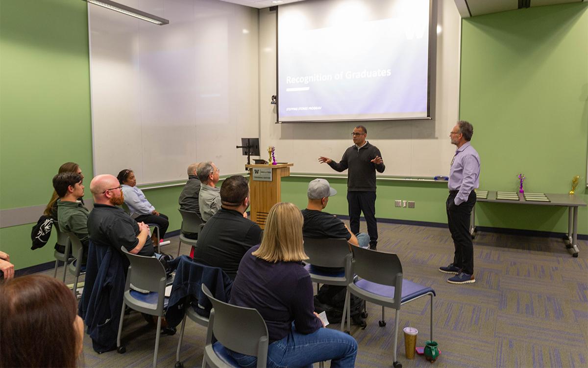 two men stand in front of classroom