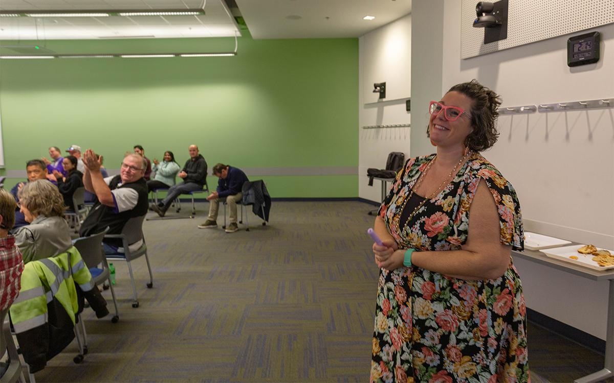 woman smiles as people give her applause