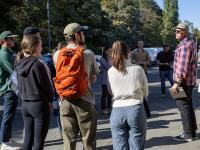 man talking to group of students in parking lot