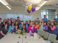 Leula Amaha with surrounded by crowd of co-workers