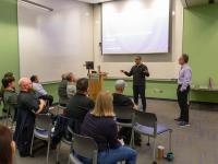 two men stand in front of classroom