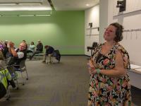 woman smiles as people give her applause