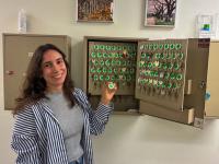 woman stands in front of cabinet with dozens of keys