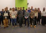 group of people posed together, half of them hold diplomas