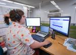 person sits at desk with two screens