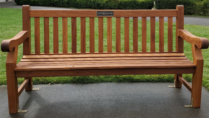 a memorial resting bench set on a pad of bricks