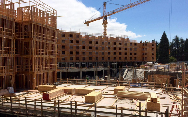 north campus housing construction phase wood framing with crane in background