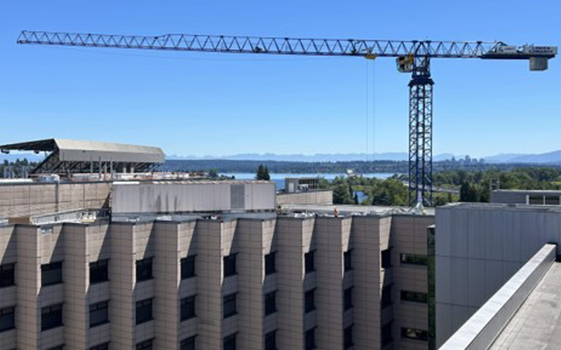 large construction crane extended over uwmc building roof