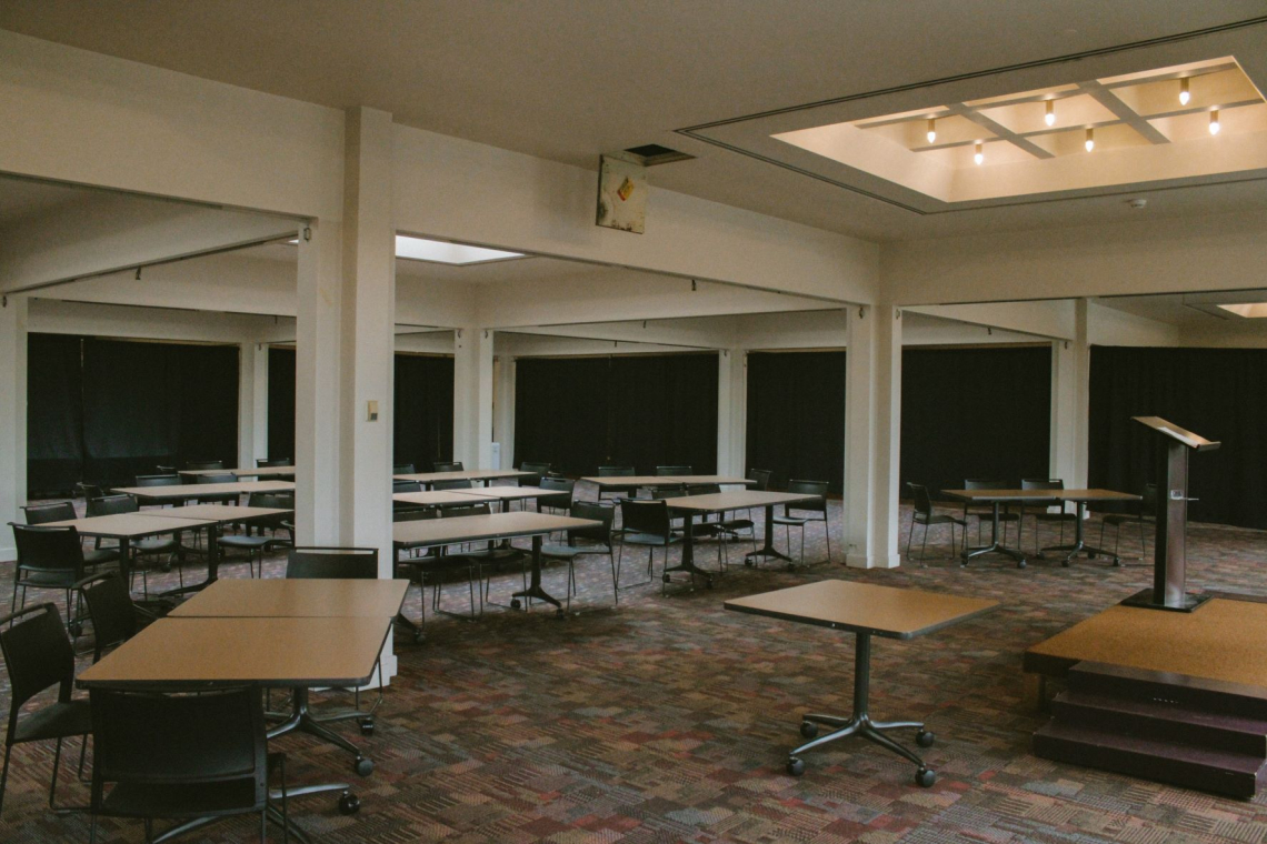 The mezzanine south cafeteria with small tables arranged in an arc with focus on a podium