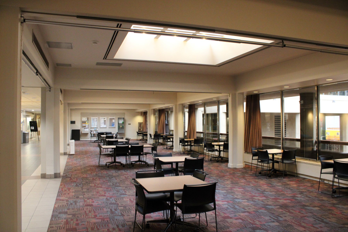The mezzanine north cafeteria with 3-4 person tables arranged on a pinkish geometric carpet