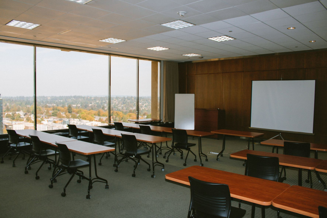 Ravenna Training Room with tables lined up to face the projector screen