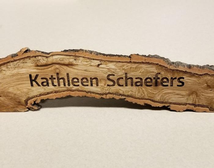 wood branch split and finished with name engraved on surface