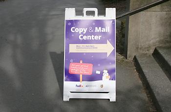sandwich board for copy center on sidewalk outside communications building