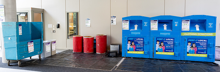 scram site with blue and red bins to collect donations