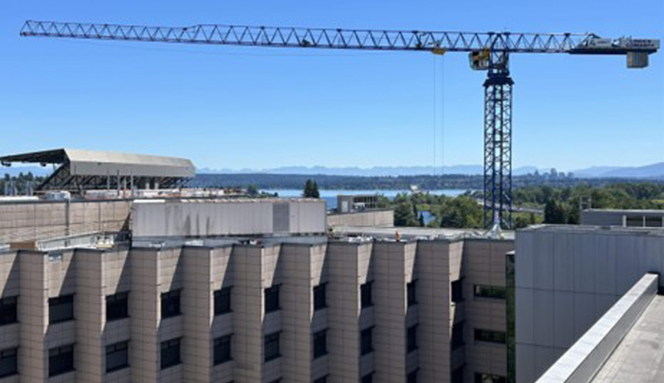 large construction crane extended over uwmc building roof