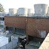 brick building with water raining down and with concrete towers on top