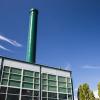 power plant building and green smoke stack with blue sky background