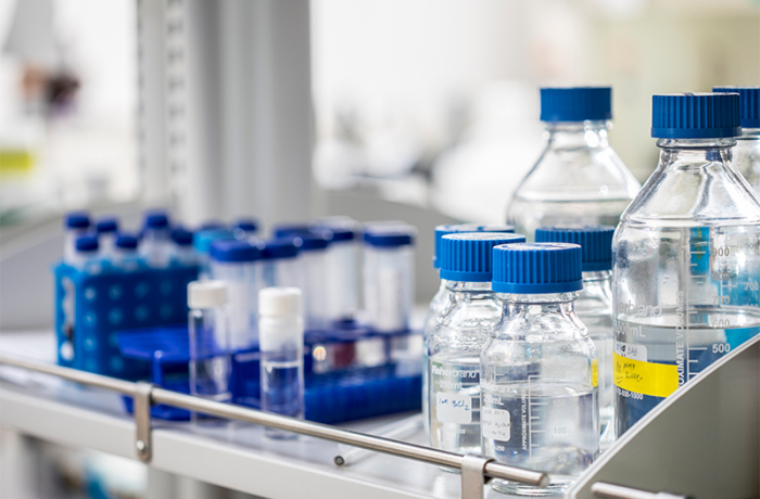 glass bottles in a lab filled with clear liquids