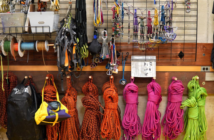 a significant amount of rock climbing gear on a wall display shelf