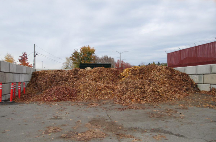 leaves and compost pile surrounded by a cinder block structure