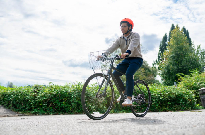 person riding a bike with an orange helmet on