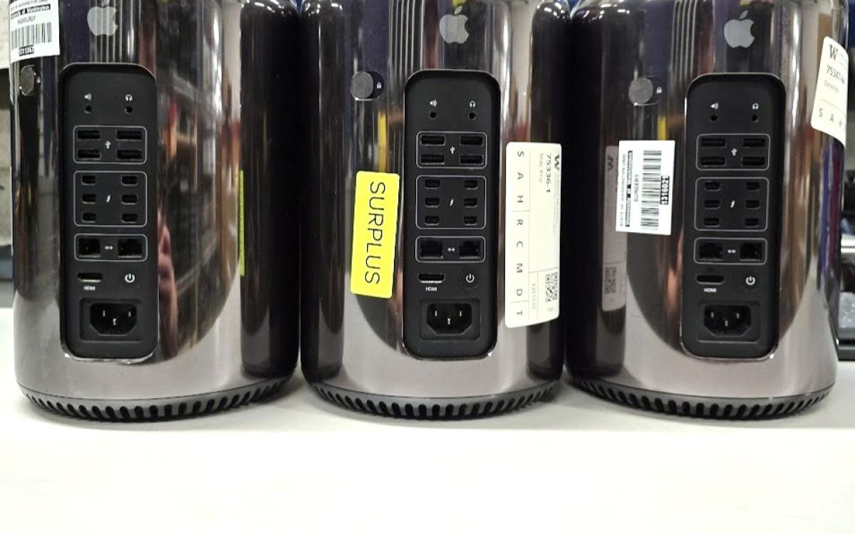 Three black round apple Mac Pro computers.