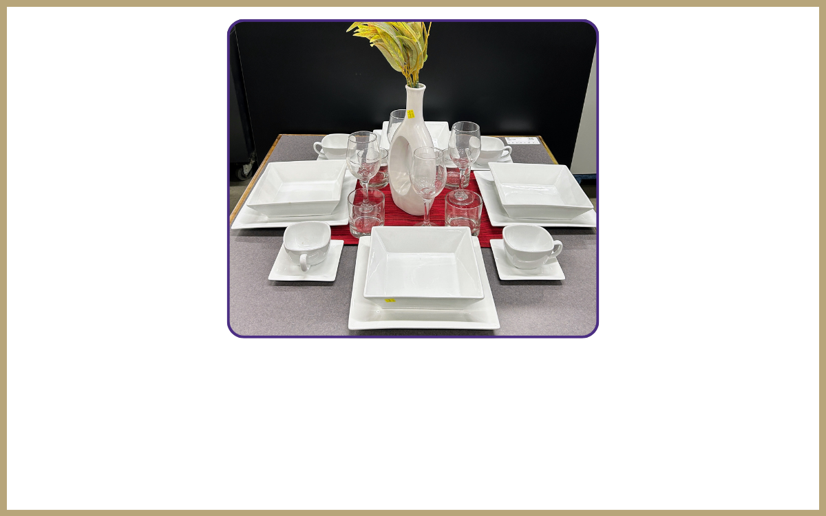 a table with cups, plates, mugs, a vase and placemats