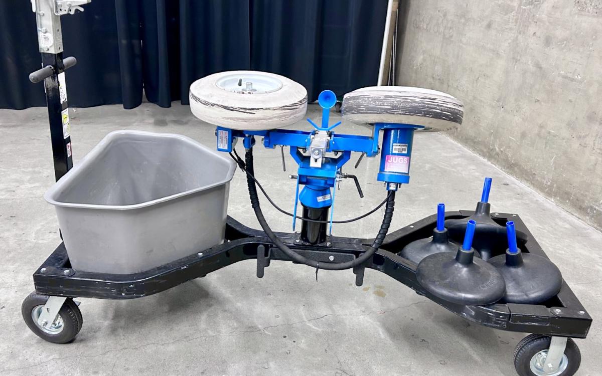 A football pitching machine on its rolling cart with trailer hitch.
